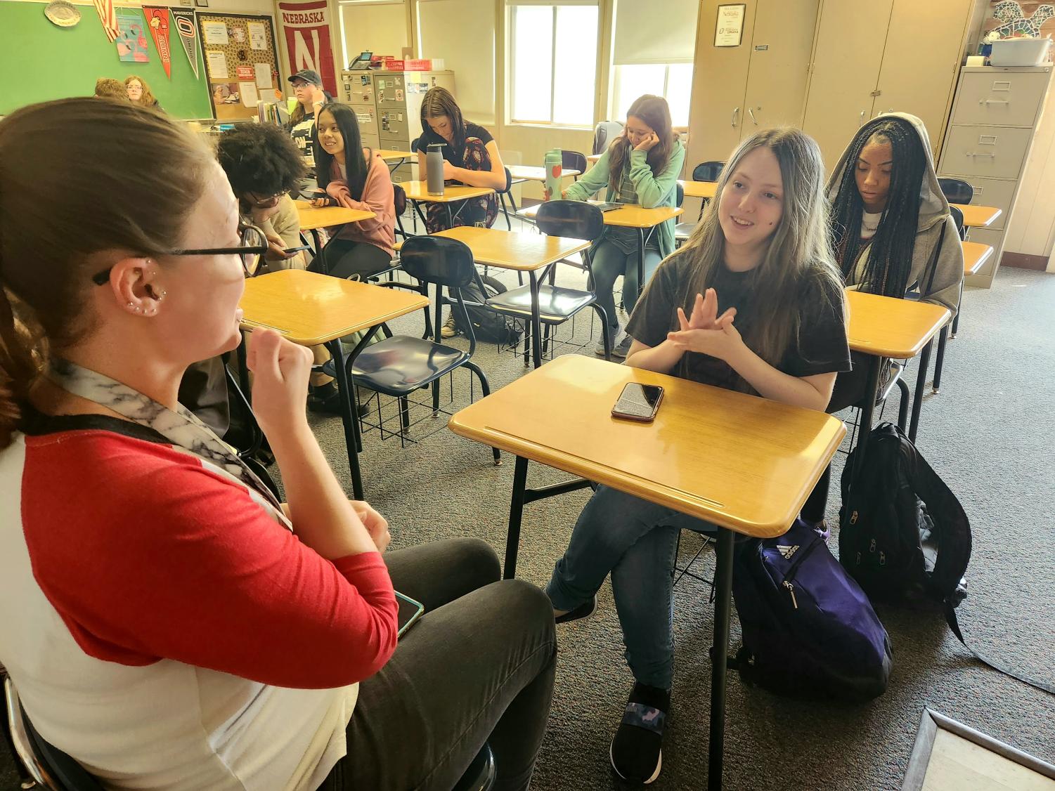 During the start of block three, sign language interpreter Kelsey Stearns, signs with hard of hearing student, junior Chase White about school. 