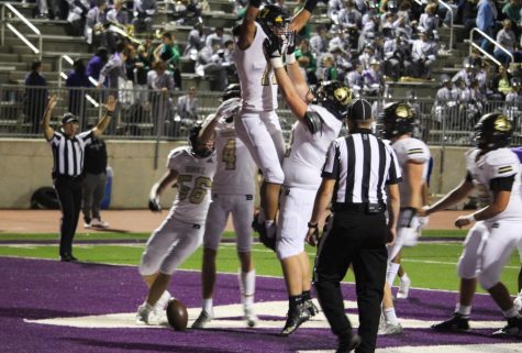 Celebrating their first touchdown of the game, Jacob Peterson lifts number 17, Jamari Allen in the air as the rest of the team cheers around them in the end zone.