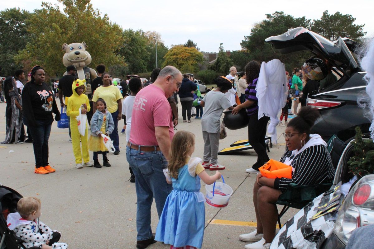 Olivia Wells (12) happily gives out candy from her Nightmare Before Christmas themed trunk after talking to a child and her parent. 