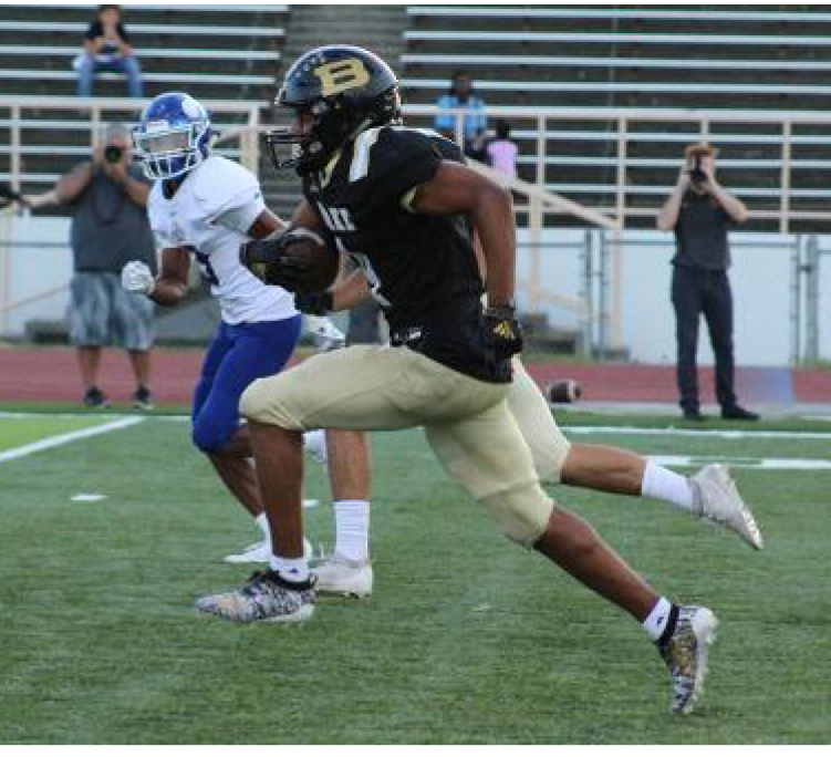 Former Bulldog football player Xavier Watts runs the ball past defenders in his senior season.