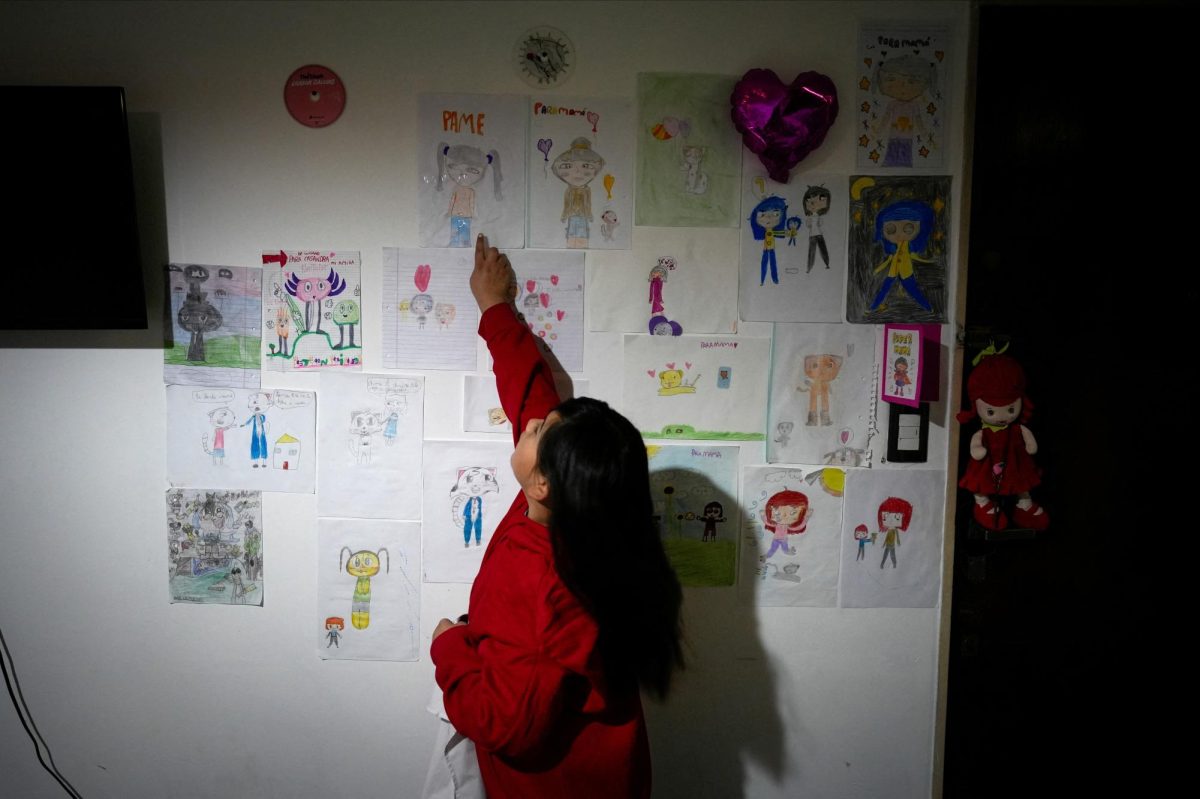 Casandra Fernandez, daughter of nurse Pamela Luciana Barraza Lucena, who works at Garrahan children's hospital, a leading center for pediatric surgery and organ transplants that is now at the heart of the country's escalating public hospital crisis, points at a drawing she made of her mother, at their home in Buenos Aires, Argentina, August 13, 2025. REUTERS/Mariana Nedelcu