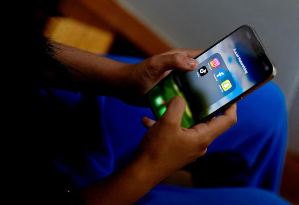 A high school student poses with her mobile showing her social media applications in Melbourne, Australia, November 28, 2024. REUTERS/Asanka Brendon Ratnayake/File photo