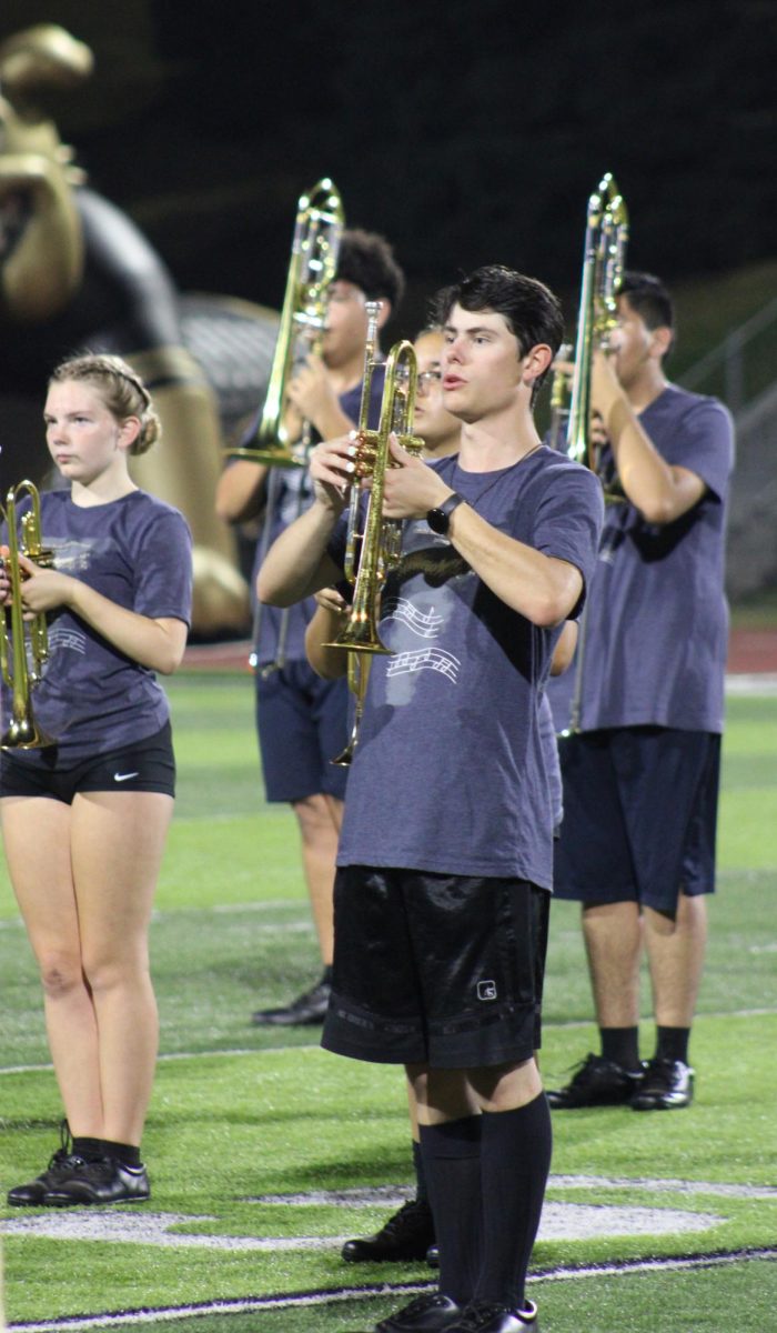 Bryson Huebert (12) plays trumpet enthusiastically for the football halftime show against Westview Highschool. 