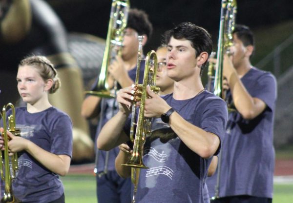 Bryson Huebert (12) plays trumpet enthusiastically for the football halftime show against Westview Highschool. 