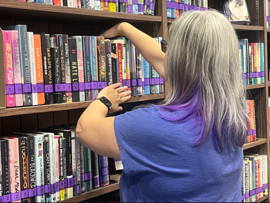 Ms. McCune organized books on the shelf so students later can easily find their book.