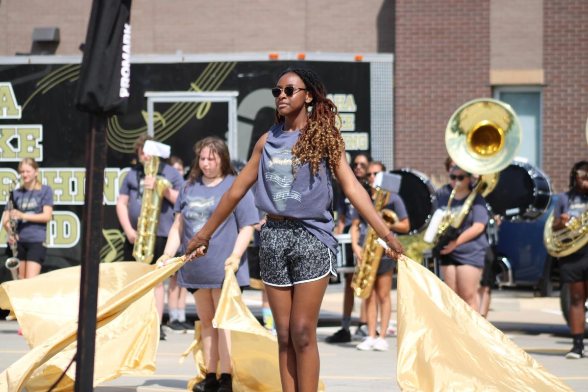 Jonae Davis (Senior) performs with energy at march-a-thon. Davis is a member of colorguard in her final year of high school. “It’s very tiring but very fun to be able to spend time with people” Jonae Davis said. 
