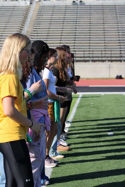 Eight grade students lining up on a yard line, ready to march.