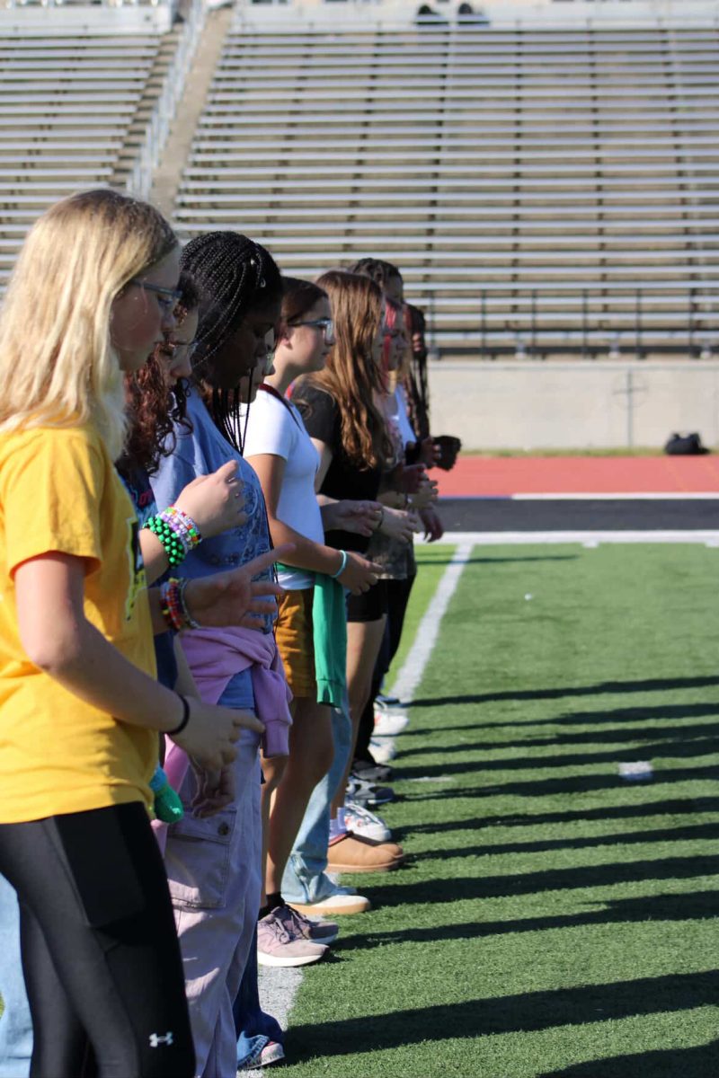 Eight grade students lining up on a yard line, ready to march.