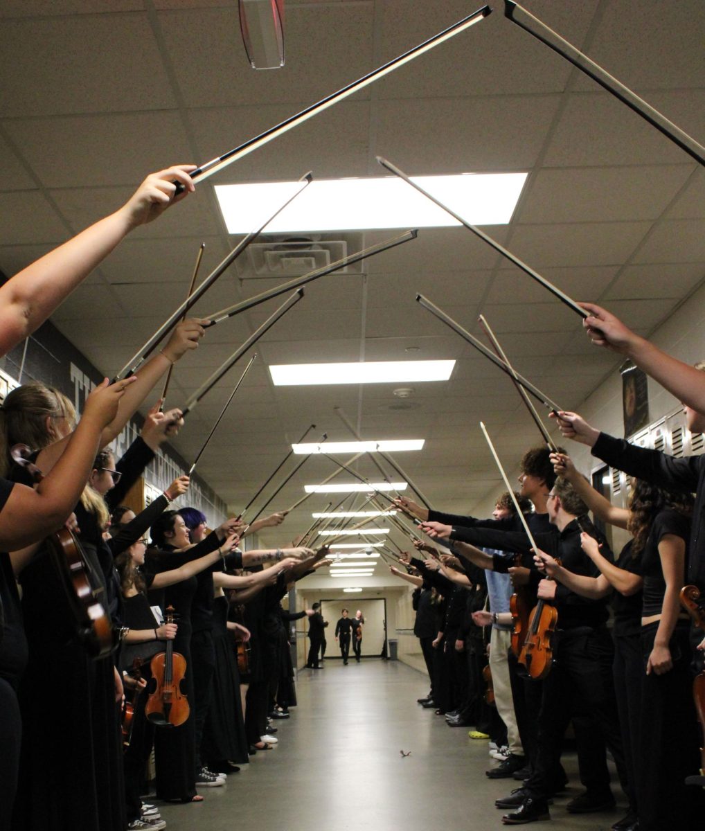 The orchestras make a bow tunnel to welcome their new members.
