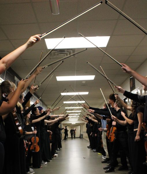 The orchestras make a bow tunnel to welcome their new members.