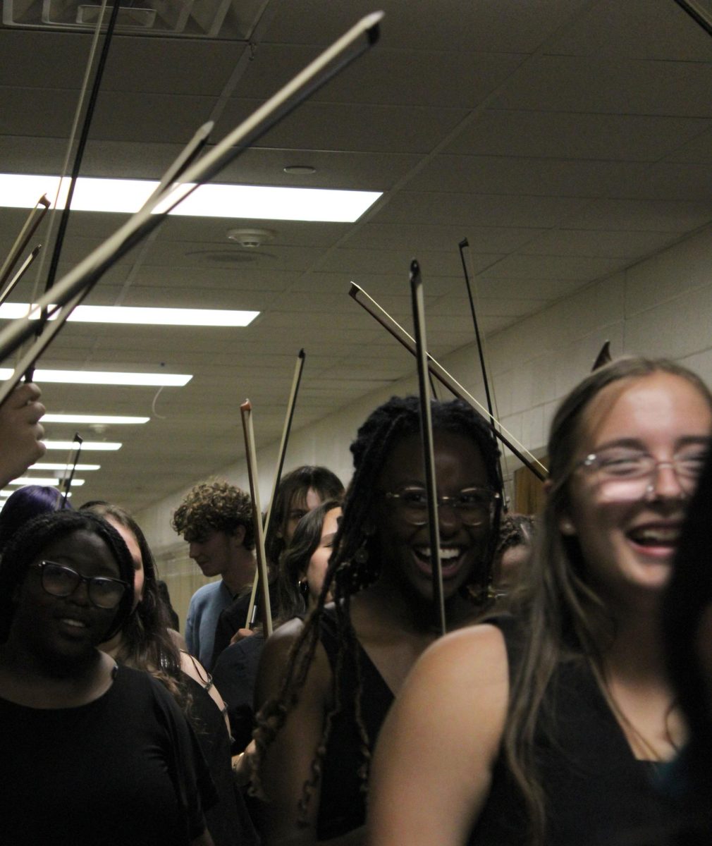 Orchestra students smiling through the crowd.