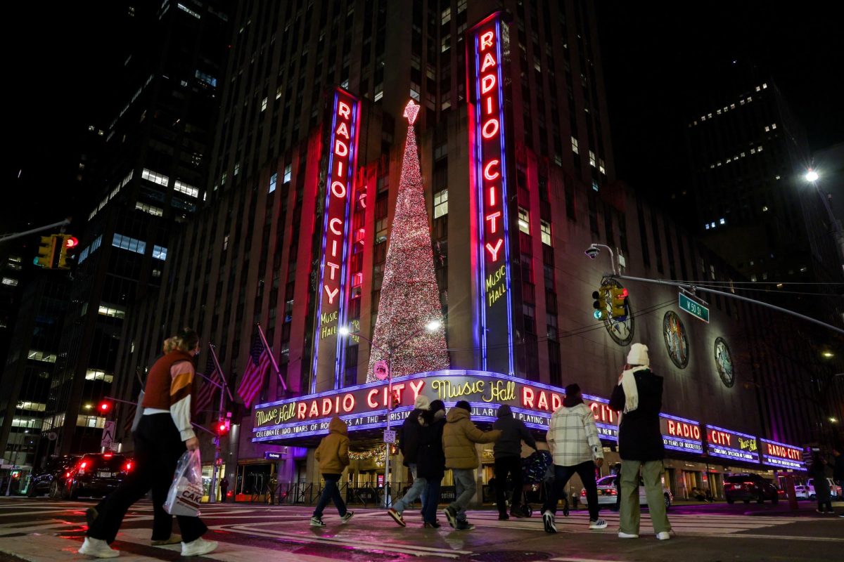 People walk by Radio City Music Hall, decorated with holiday lights, in Manhattan, New York City, U.S., November 15, 2025. REUTERS/Kylie Cooper