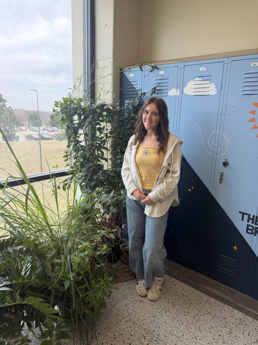 Irene standing near the potted plants in Burkes hallways