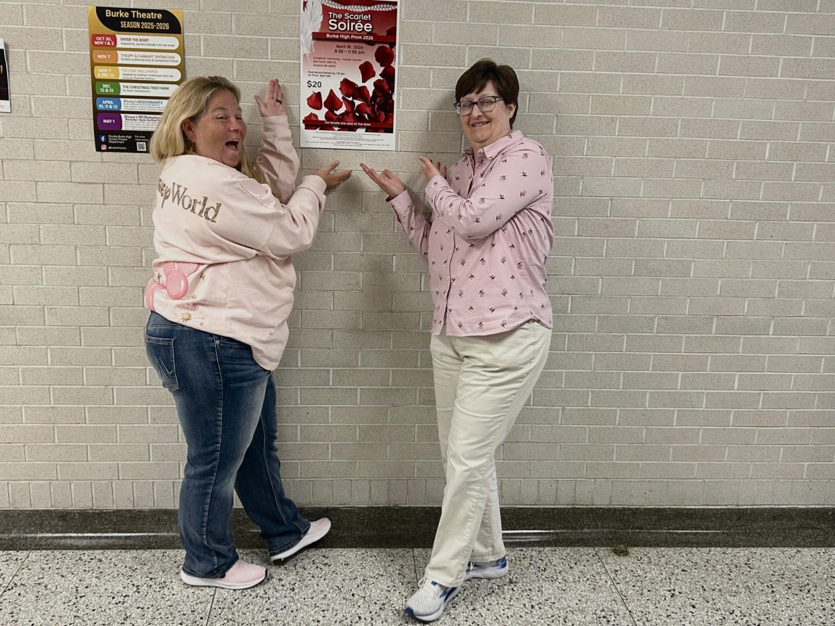Ms. Ludwig and Ms. Burton posing while showing off the prom poster.
